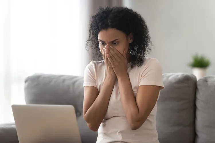 A worried business owner reading an email on a laptop